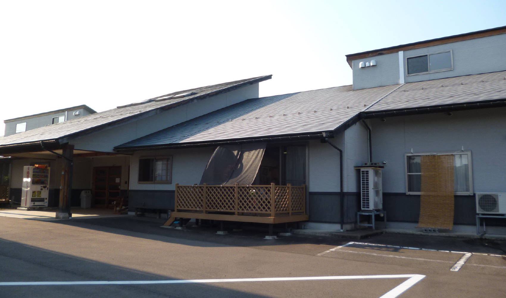 介護施設の建物外観。平屋造りで車寄せと木製デッキが見える